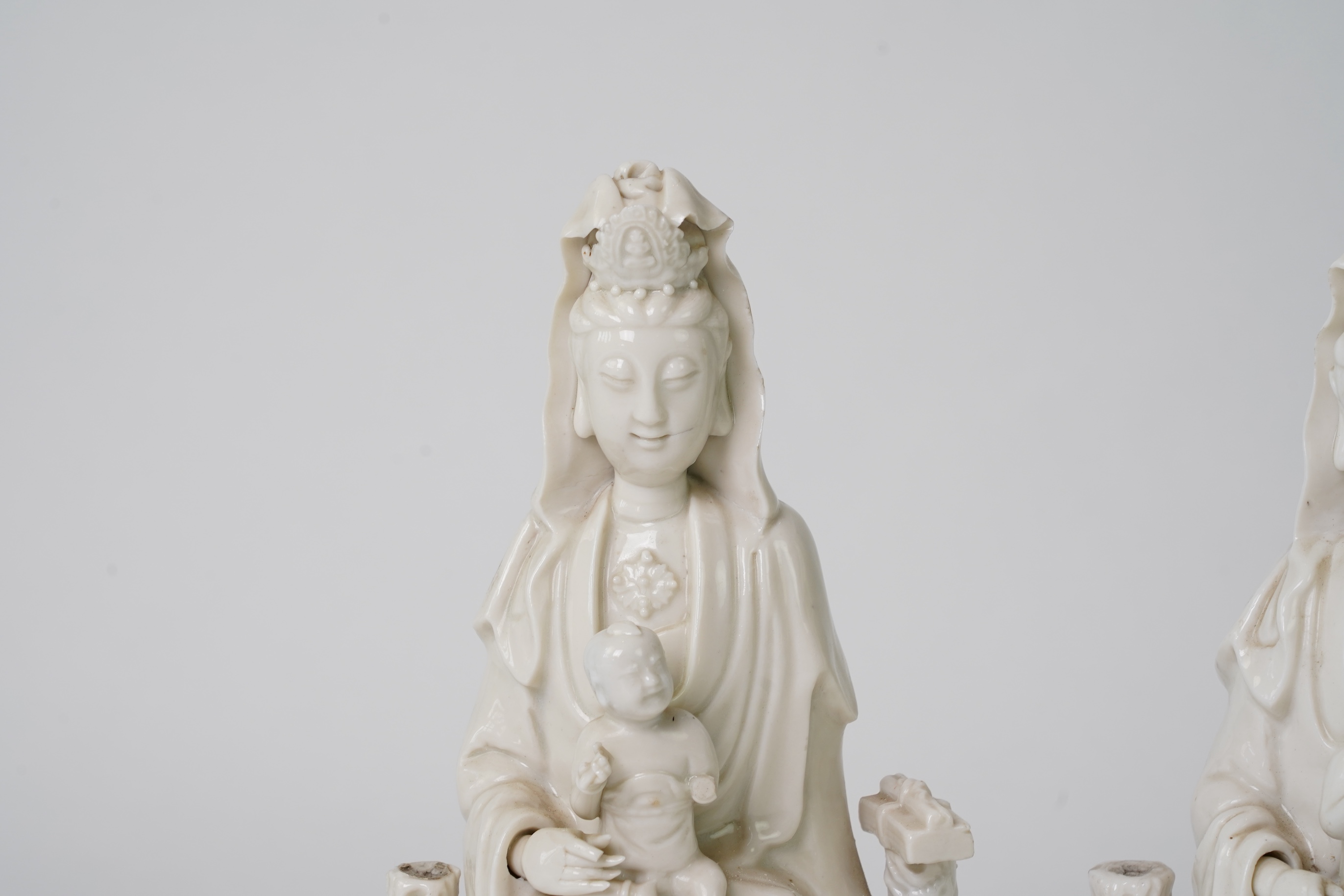 A pair of Chinese blanc de chine groups of Guanyin and children, 18th century